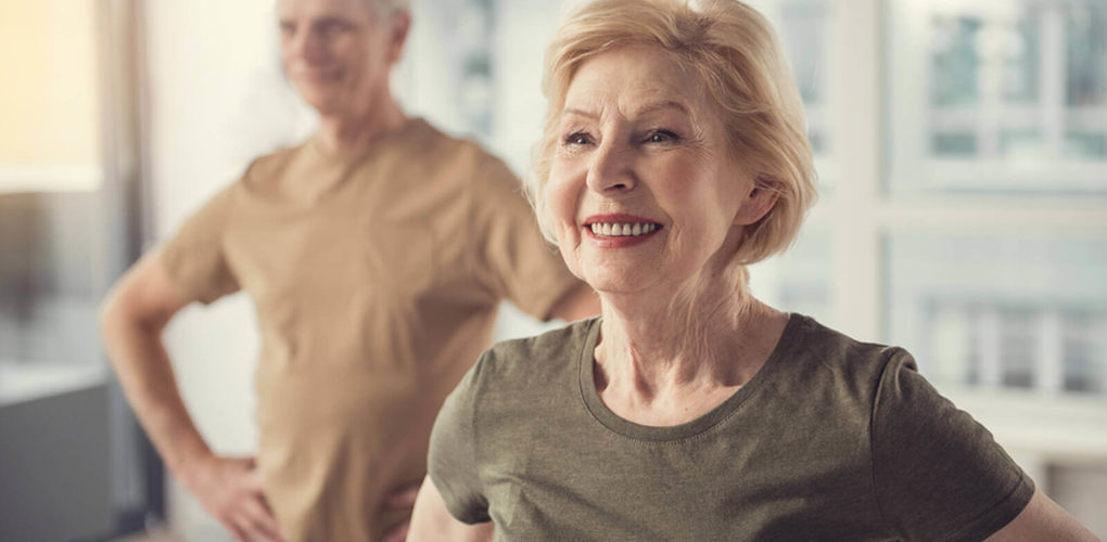 smiling elderly couple exercising
